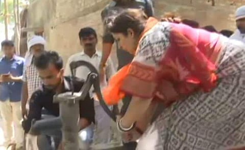 Union minister Smriti Irani on Sunday helped in fire-fighting operations in an Uttar Pradesh village. (Photo | ANI)