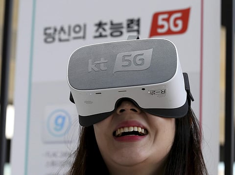 In this Tuesday, April 2, 2019 photo, an employee of KT Corp. wears a VR device for an audio-visual experience during a press conference on 5G service at its the headquarters in Seoul, South Korea. (Photo | AP)