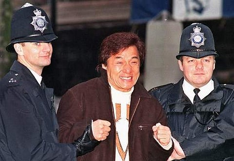 Jackie Chan hams it up with two London 'bobbies' on November 19,1998 during a film shoot to promote the new hit action comedy 'Rush Hour'. Chan who plays Detective Inspector Lee of the Hong Kong Police. 'Rush Hour' has taken a staggering $130 million dollars at the US box office to date, breaking records for the biggest ever opening in the months of its release. (File Photo | AFP)