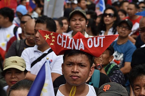 Anti-China protesters raise placards and national flags during a protest in front of Chinese consular office in the financial district of Manila.( Photo | AFP)