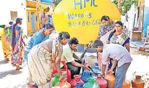 Residents line outside a water tanker
