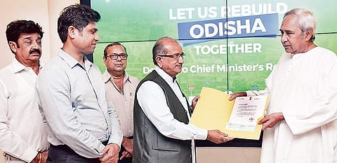 Education and Law Minister of Gujarat Bhupendra Singh Chudasama and Rajkot Municipal Corporation Commissioner Banchhanidhi Pani handing over the cheque to Chief Minister Naveen Patnaik on Monday I Express