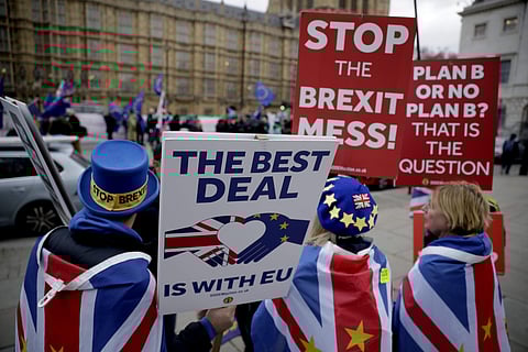 Anti-Brexit remain in the European Union Supporter Steve Bray (Left) holds placards as he demonstrates with others opposite the Houses of Parliament in London. (Photo|PTI)