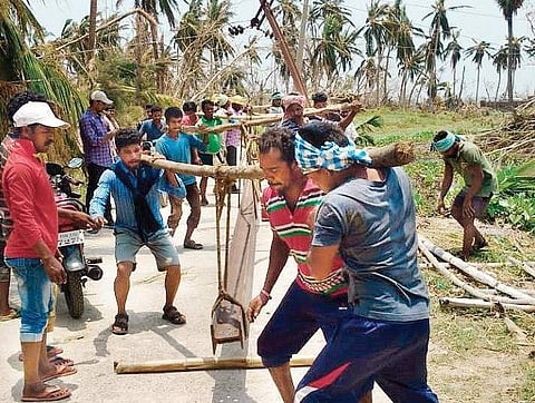 Telangana power sector employees helping Odisha government to restore power by erecting electricity poles on Tuesday. (Photo | EPS)