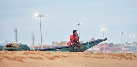 A fisherman looks contemplatively towards the sea on Puri beach on Tuesday as extremely severe cyclone Fani approaches Odisha coast | Express