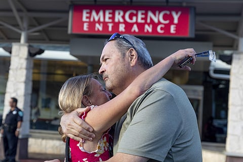 Sarah Haynes, left, embraces John Eller, father of Amanda Eller, outside the Maui Memorial Hospital in Wailuku, Maui. (Photo | AP)