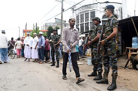 Sri Lankan security personnel stand guard as Sri Lankan Muslims gather after Friday noon prayers to remember the victims and to protest against the terrorist group who was responsible for Easter Sunday suicide attacks that killed 258 people in Sri Lanka |