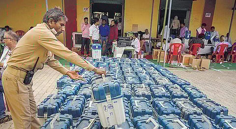Polling official arranges VVPATs at a distribution centre in Prayagraj, Uttar Pradesh. EC has mandated GPS-tracking for all vehicles transporting EVMs and VVPATs | pti