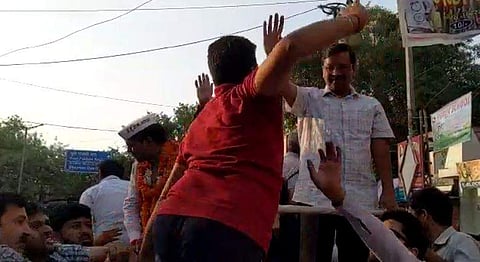 A man in red T-shirt slaps Delhi CM Arvind Kejriwal. (Photo | Screengrab from the video)