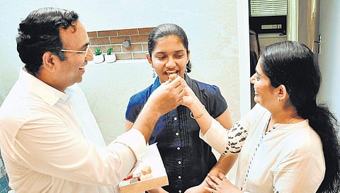Bhavana Sivadas being offered sweets by her parents Dr Naveen Sivadas and Deepthi