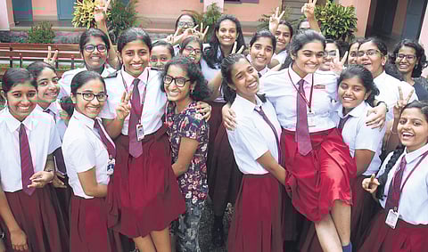 Students of St Thomas Central School at Mukkolakkal raising Riya Renu Thomas and Namrata Nandagopal who won state second ranks in the ICSE examination, the results of which were published on Tuesday | B P Deepu