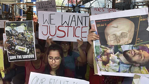 Junior doctors hold placards during a demonstration on 13 June 2019 after an intern doctor was attacked and seriously injured over the death of a 75-year-old patient at Nil Ratan Sircar Medical College and Hospital in Kolkata. (Photo | PTI)