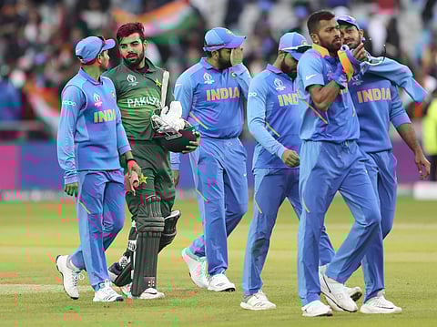 Pakistan's Shadab Khan, second left, leaves the field with Indian players after their loss in the Cricket World Cup match between India and Pakistan at Old Trafford in Manchester, England, Sunday, June 16, 2019. | AP