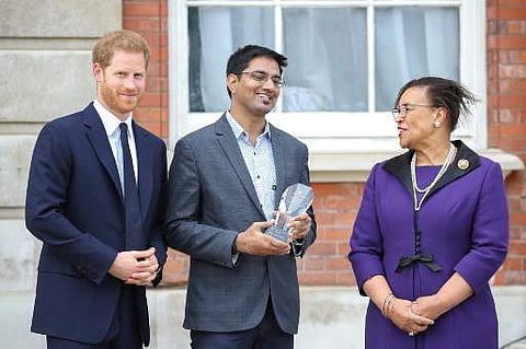 Britain's Prince Harry, Duke of Sussex (L) and Secretary-General of the Commonwealth, Patricia Scotland (R) pose with Nitesh Kumar Jangir, one of the winners of the Commonwealth Secretary-General's Innovation for Sustainable Development Awards during a ga