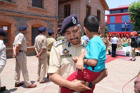 Haseeb Mughal, the Senior Superintendent of Police in Srinagar, breaks down while carrying the 4-year-old son, Uhbaan of inspector Arshad Khan who died in the Anantnag encounter on 17 June 2019. (Photo | Twitter)