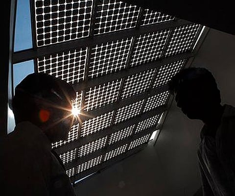 Official stands under an atrium roof fitted with glass solar cells at The Energy and Resources Institute in Gurgaon, India. Image used for representational purposes. (Photo | AP)