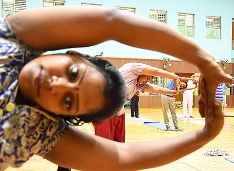 People practise yoga asanas at the open auditorium on RSVP campus in Tirupati. (Photo | Madhav K, EPS)