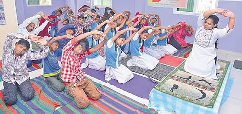 Children and adults perform yogaasanas at Triguna Nature Cure and Yoga Clinic Centre in Guntur on Thursday. (Photo I EPS)