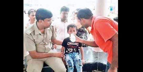 The boy, Karan Sheikh being fed water by Digha residents after he was rescued from the car.