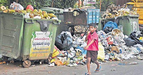 A file photograph of a boy walking past a garbage heap in Vijayawada | Express