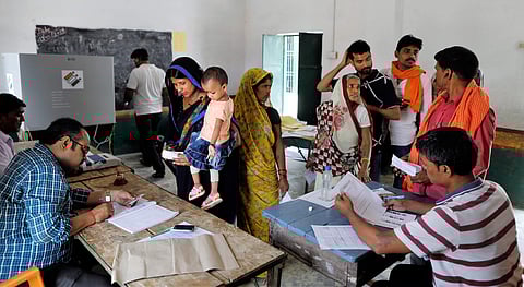 Election officers check the identity of voters before allowing them to cast their votes during the seventh and final phase of national elections, on the outskirts of Varanasi. (File | AP)