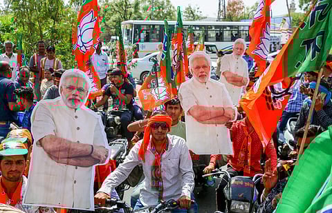 BJP supporters with Modi posters and flags at a rally during the Lok Sabha election campaign. (File Photo | PTI)
