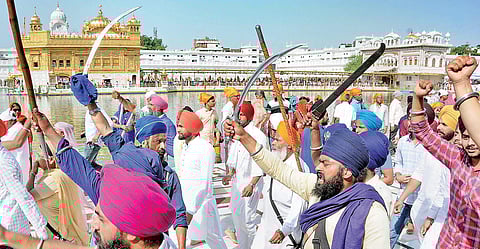 Members of radical Sikh organizations shout slogans and brandish swords during a demonstration on the 34th anniversary of Operation Blue Star on Thursday | PTI