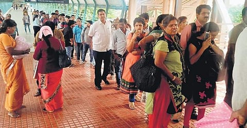 Long queues are a common sight at the single ticket counter on the foot overbridge at KSR station.