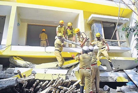 Rescue personnel conduct rescue operations in the buildings which collapsed in Cooke Town