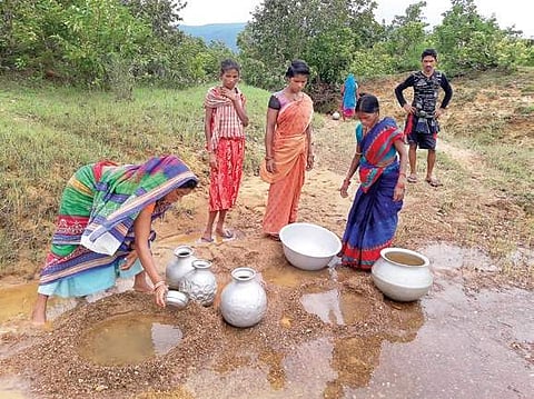 Women residents of Kaju Sahi collecting water from a pit | Express
