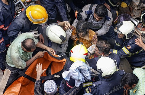A girl rescued by NDRF personnel at the incident site after collapse of the four-storey Kesarbai building at Dongri in Mumbai Tuesday July 16 2019. (Photo | PTI)