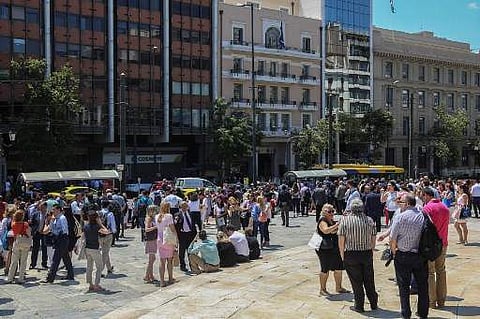 People stand outside buildings in central Athens after an earthquake (Photo | AFP)
