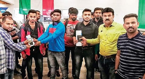 Indian expats hand over passports and tickets to Mangaloreans, who had become victims of the job fraud, at Kuwait airport (Photo | EPS)