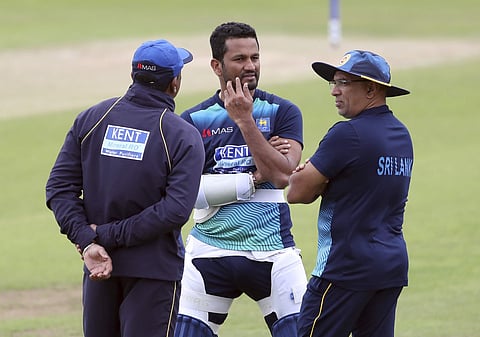 Sri Lanka's captain Dimuth Karunaratne, center, interacts with team coach Chandika Hathurusingha, right, during a training session | AP