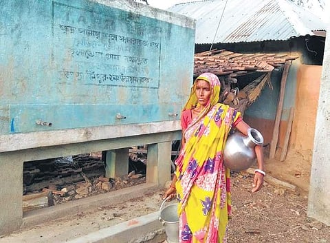 Lakshimoni Murmu walks by a water reservoir that has been lying unutilised for the last six years in Jungle Mahal, Bengal. (Photo | Pranab Mondal, EPS)
