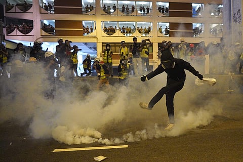 A protestor kicks a tear gas canister during  the confrontation with police. (Photo | AP)