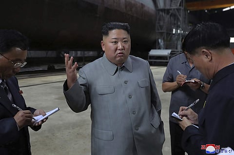 North Korean leader Kim Jong Un, center, speaks while inspecting a newly built submarine to be deployed soon, at an unknown location in North Korea. (Photo | AP)