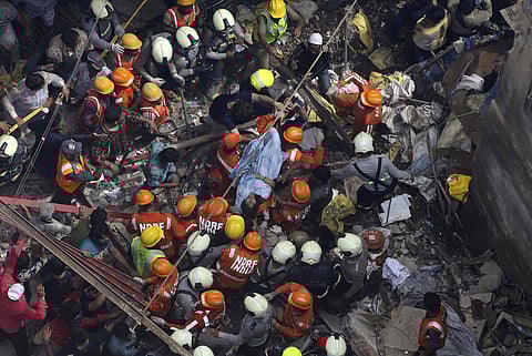 Rescuers carry out a survivor from the site of a building that collapsed in Mumbai. (Photo | AP)