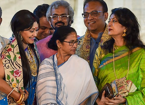 Actresses Debasree Roy (R) and Indrani Halder (L) after receiving 'Mahanayak Samman' pose for a photo with West Bengal Chief Minister Mamata Banerjee (C) during an event to commemorate 39th death anniversary of the legendary Bengali actor Uttam Kumar in K