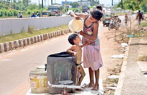 A girl bathes her sibling as heat and humidity make life miserable in Bhubaneswar. Image used for representative purposes only
