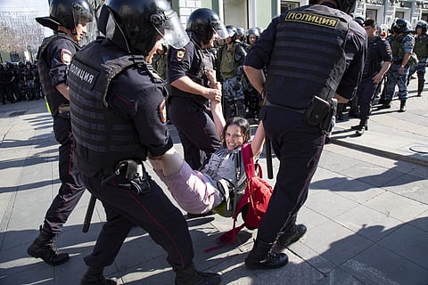 Police officers detain a woman during an unsanctioned rally in the center of Moscow, Russia. (Photo  | AP)
