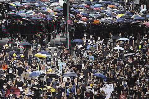 Protesters use umbrellas to cover themselves as they set up barricades during a march on a street in Hong Kong. (Photo | AP)