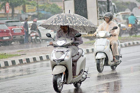 Commuters take cover from a sudden downpour in Bhubaneswar | Express