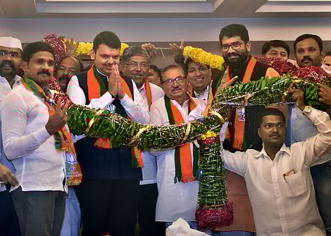 Maharashtra Chief Minister Devendra Fadnavis with Nationalist Congress Party NCP leaders who recently joined BJP - Madhukar Pichad Chitra Wagh Shivendra Raje Bhosale Sandeep Naik and Vaibahv Pichad - being garlanded by supporters in Mumbai Wednesday July 