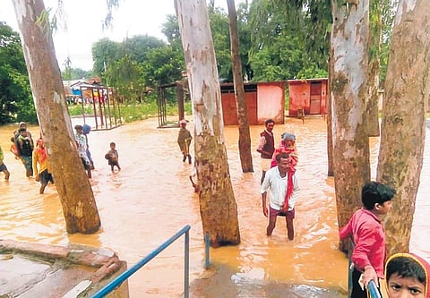 People of Chirma village under Kosagumuda block of Nabarangpur district moving to panchayat office after flood water entered their village on Tuesday | Express