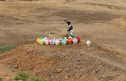 A woman fetch water from an infiltration well inside the river bed at Ramanathapuram.( Photo | Ponmalar, EPS)