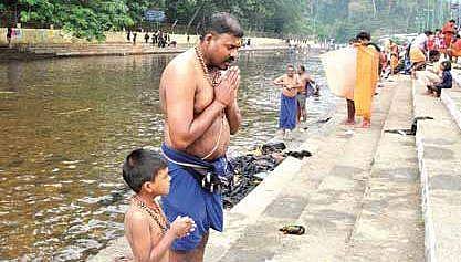 Pilgrims offering prayers near the Pampa river before proceeding to Sabarimala Lord Ayyappa temple on Thursday (File Photo | EPS, Shaji Vettipuram)