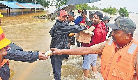 Rescue personnel hand out relief material to flood-hit residents in Belagavi district  | D hemanth