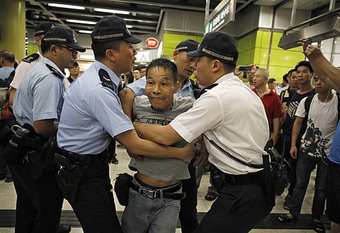 Police restrain an angry passenger who tried to fight with protesters in Hong Kong on Tuesday (File Photo | AP)