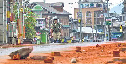 A security personnel stands guard during curfew-like restriction on the fifth consecutive day in Srinagar | PTI